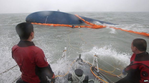Rescuers near hull of boat
