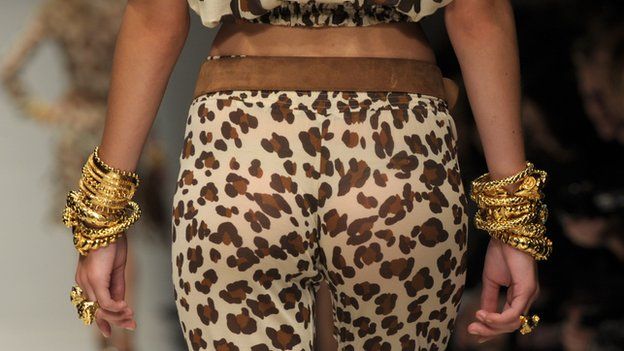 Female model's bottom in leopard skin trousers as she walks up the catwalk
