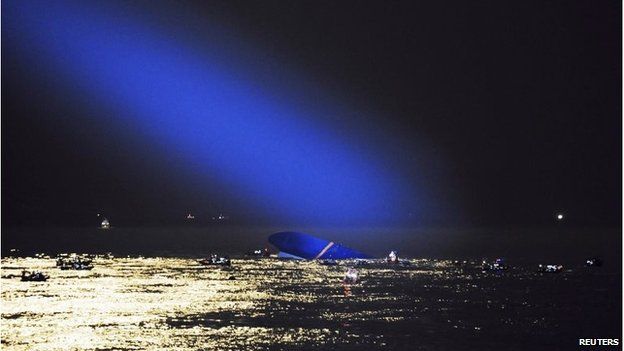 The wreck, lit up by a helicopter's spotlight at night