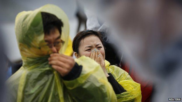 Family members of passengers missing on the overturned South Korean ferry Sewol, react at the port in Jindo