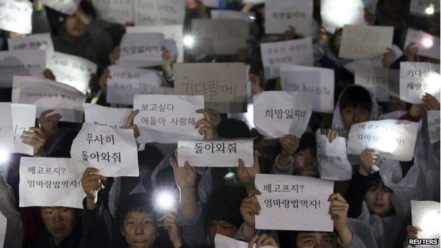 Students hold signs with messages of hope for the return of their missing friends who were on the Sewol ferry, which sank in the sea off Jindo, at Danwon High School in Ansan on 17 April 2014