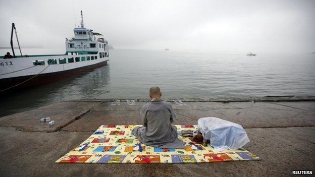 A Buddhist monk prays for missing passengers who were on the South Korean ferry "Sewol" which sank in the sea off Jindo at a port where family members of missing passengers gathered in Jindo on 18 April 2014