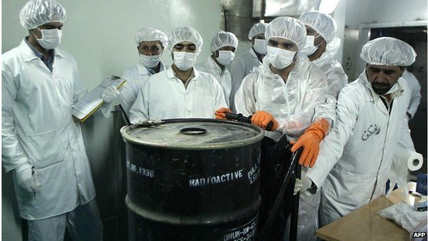 Iranian technicians remove container of radioactive uranium (file photo)