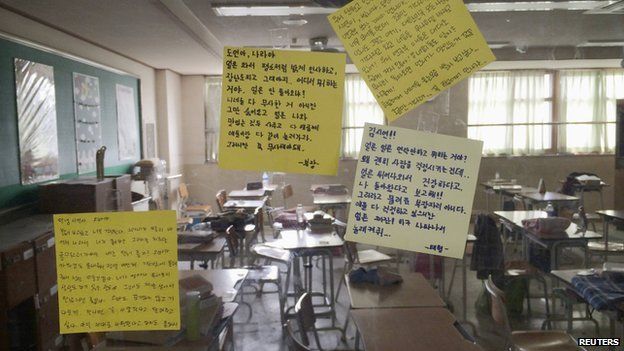 Messages left by fellow students are stuck to the classroom windows of students missing in the South Korean ferry disaster at Danwon High School in Ansan on 18 April 2014.