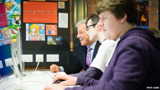 John Bercow looking at a computer screen alongside two young people