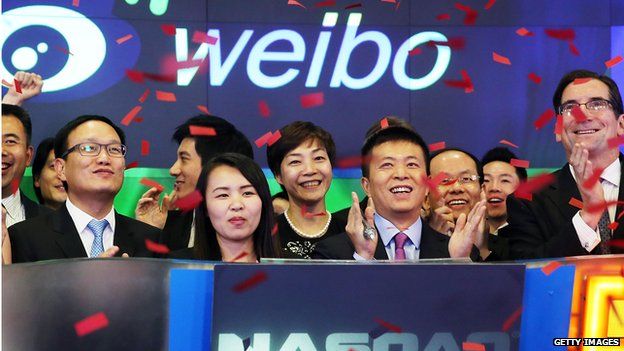 Weibo CEO Charles Chao (centre) stands with Robert Greifeld, Nasdaq CEO, moments after Weibo began trading on the Nasdaq exchange