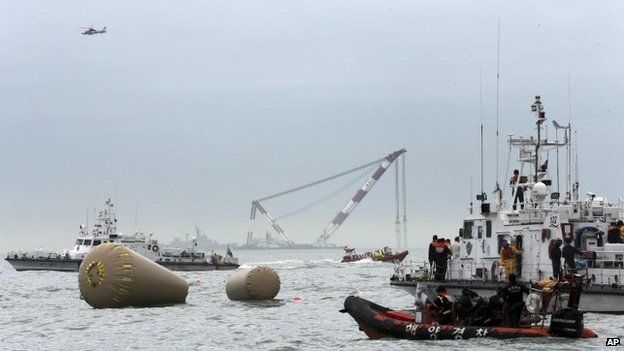 South Korean Navy personnel work on buoys to mark the sunken passenger ship Sewol in the water off the southern coast near Jindo, South Korea, Friday, April 18, 2014