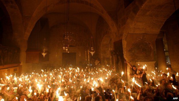 Christian pilgrims hold candles inside the Church of the Holy Sepulchre (19 April 2014)