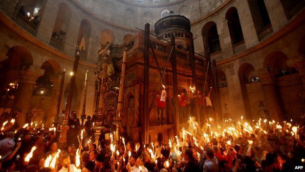 Christian pilgrims hold candles at the Church of the Holy Sepulchre in Jerusalem (19 April 2014)