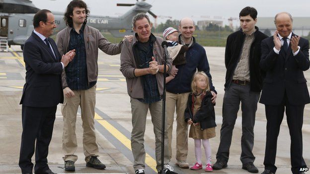 Freed journalists with President Hollande and Foreign Minister Laurent Fabius at Villacoublay air base on 20 April 2014