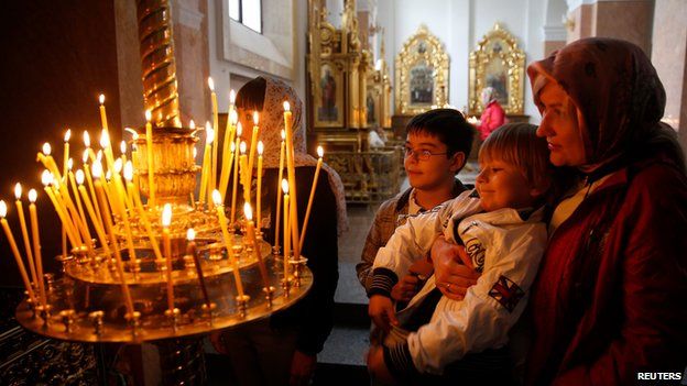 Ukrainian Orthodox believers light candles in a church in Donetsk, eastern Ukraine, on 20 April 2014