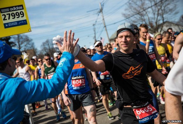 A runner gives a high fives a supporter at the beginning of the Boston Marathon on 21 April 2014
