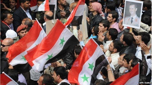 A handout picture released by the official Syrian Arab News Agency (SANA) on April 21, 2014 shows Syrians holding their national flags and a portrait of President Bashar al-Assad during a rally