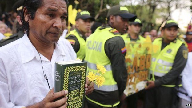 A man holds a copy of One Hundred Year of Solitude during a symbolic funeral in Aracataca, Monday, April 21, 2014.