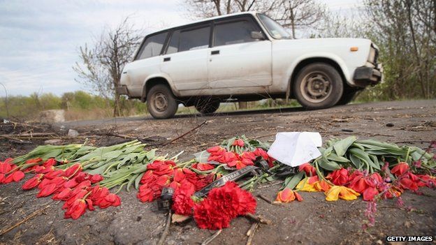 Flowers lay in the road as a memorial to three men shot on Easter Sunday at a checkpoint near Sloviansk