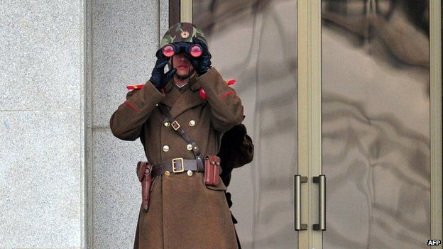 A North Korean soldier looks on at the South side at the truce village of Panmunjom in the Demilitarised Zone dividing the two Koreas on 12 March 2014