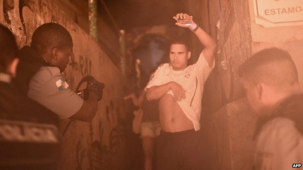 Police detain a man during a violent protest in a favela near Copacabana in Rio de Janeiro, Brazil, on 22 April 2014.