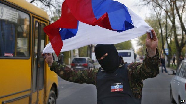 A masked pro-Russia protester waves the Russian flag in Donetsk, eastern Ukraine, on 22 April 2014