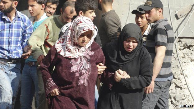 Women hold each other as they are seen at a site hit by what activists said were barrel bombs dropped by forces loyal to Syria's President Bashar al-Assad in the northern town of Atareb, in Aleppo province, 24 April 2014