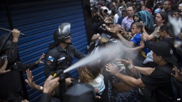 A woman is pepper sprayed by riot police during a protest in Rio de Janeiro, April 24, 2014.