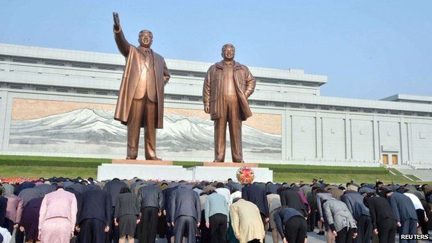 North Koreans bow in front of bronze statues of North Korea's founder Kim Il-sung (L) and late leader Kim Jong-il at Mansudae in Pyongyang, in this photo provided by Kyodo on 25 April 2014, on the 82nd anniversary of the founding of the Korean People's Army