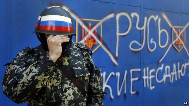 A pro-Russian militant adjusts his mask in Sloviansk