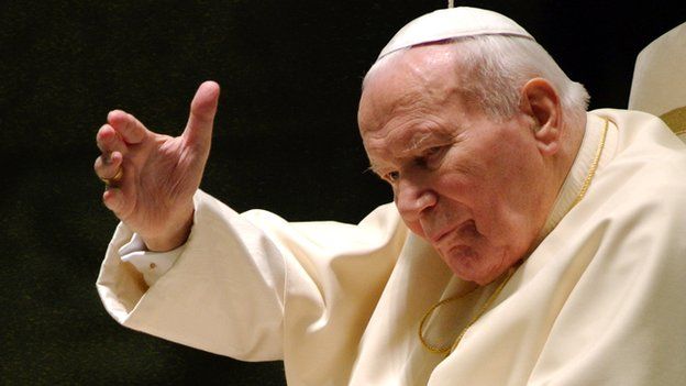 Pope John Paul II waves during his weekly audience on 17 December 2003 in Vatican City.