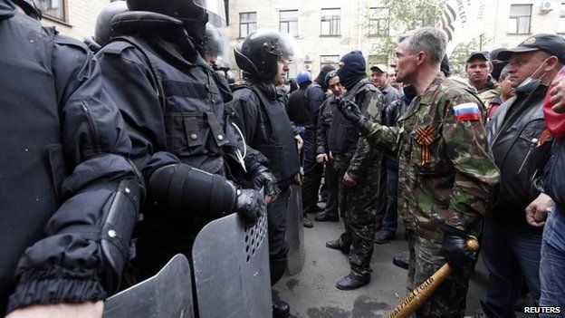 Pro-Russian activists confront interior ministry security personnel outside the regional government's headquarters in Luhansk (29 April 2014)