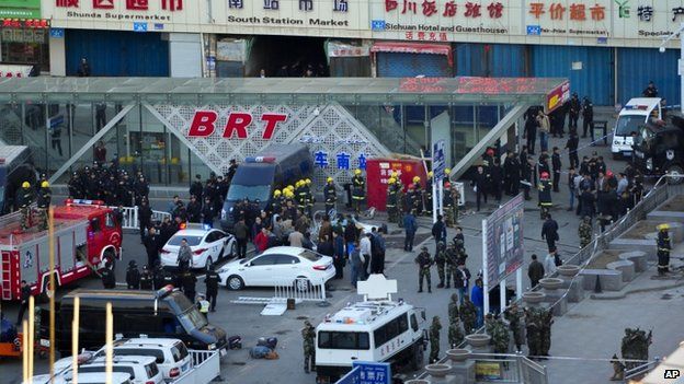 Security personnel gather near the scene of an explosion outside the Urumqi South Railway Station in Urumqi in northwest China's Xinjiang Uighur Autonomous Region on 30 April 2014