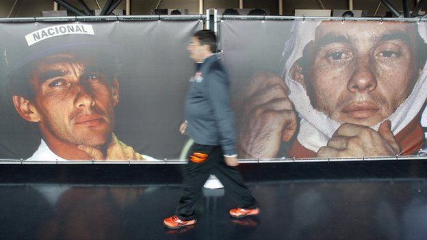 A man walks past pictures of Senna at an exhibition at the Imola race track