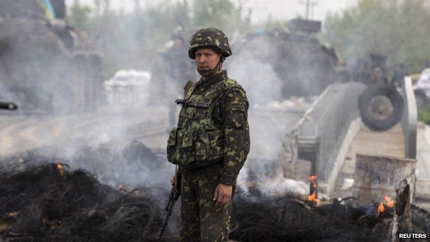 A Ukrainian solider stands near a destroyed rebel checkpoint near Sloviansk. Photo: 2 May 2014