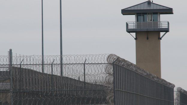 A photo of the wire fence and tower of a prison in Illinois in 2009.