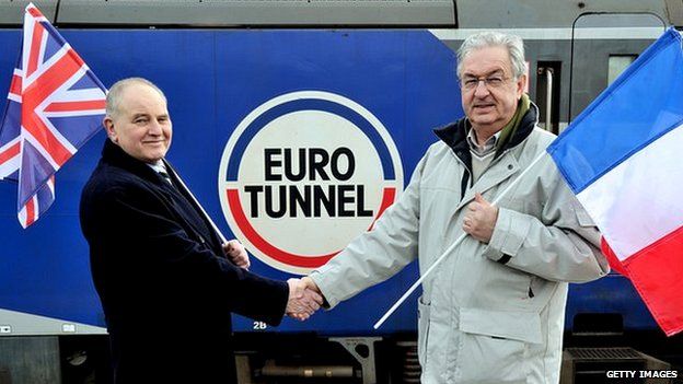 Former workers Philippe Cozette (R) and Graham Fagg, who dug the last metres of the tunnel pose in front of a train at the entrance of the tunnel, near Coquelles on 10 Feb 2014