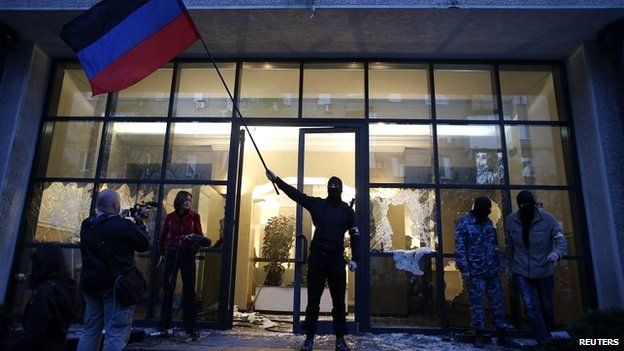 A pro-Russia protester waves a Donbass flag after storming a governor's offices in Donetsk - 3 May 2014