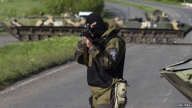 A Ukrainian soldier points his weapon at an approaching car at a checkpoint near Sloviansk - 3 May 2014