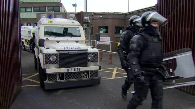 Police officers and vans emerging from Antrim PSNI base