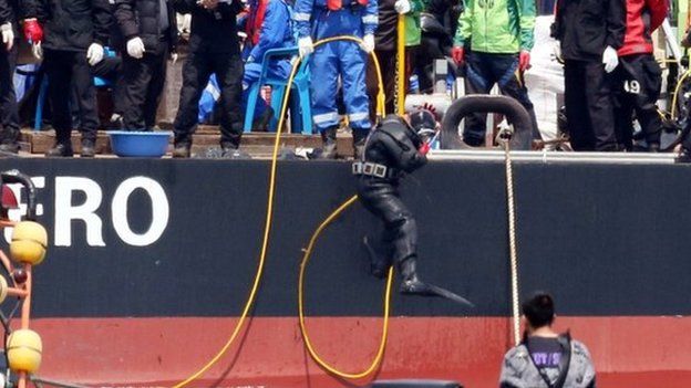 A diver jumps into the sea to search missing passengers at the site of the sunken South Korean ferry "Sewol" off Jindo on April 25, 2014.