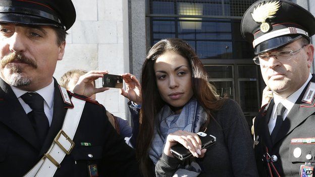 Karima el-Mahroug's is escorted outside a Milan court by two Carabinieri police officers after giving her testimony at the trial in Milan (May 2013)
