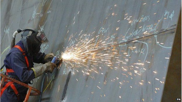A ship builder works on a section of the first of two Queen Elizabeth class aircraft carriers at BAE Systems in Portsmouth. 08/12/2010