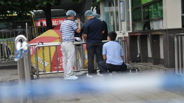 Investigators inspect the scene after a knife attack on the square of Guangzhou railway station in Guangzhou, in southern China's Guangdong province on 6 May 2014