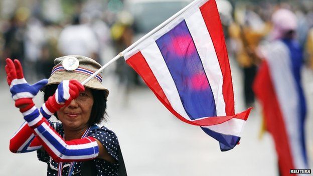 An anti-government protester marching in the city centre celebrates shortly after a Thai court delivered its verdict on Prime Minister Yingluck Shinawatra, in Bangkok, 7 May 2014