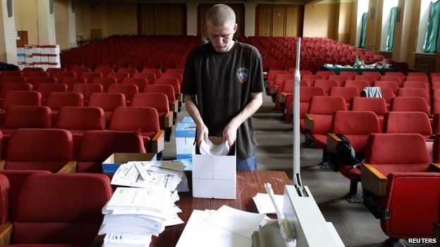 An election worker at the Donetsk self-proclaimed republic's election commission arranges referendum materials in Donetsk, 8 May