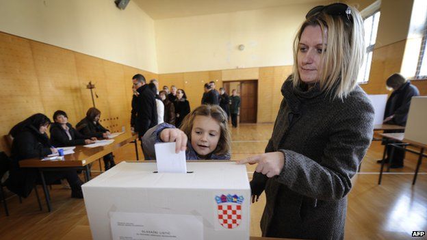 Little girl casts her mother's ballot in the Croatian referendum on EU membership on 22 January 2012