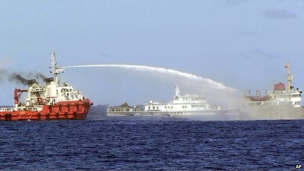 In this photo released by Vietnam Coast Guard, a Chinese ship, left, shoots water cannon at a Vietnamese vessel, right, while a Chinese Coast Guard ship, centre, sails alongside in the South China Sea, off Vietnam's coast, Wednesday, 7 May 2014