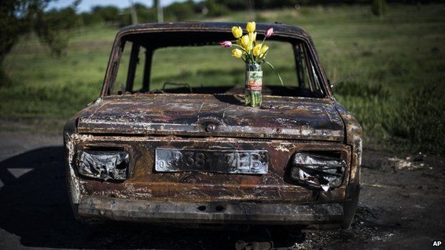 A bouquet of flowers stands on a burned car at the site of clashes between pro-Russia gunmen and the Ukrainian army, north of Sloviansk,, 7 May