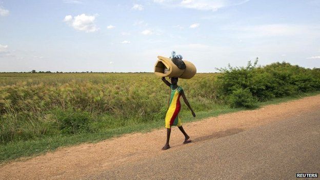 A civilian carries her belongings as she flees from renewed attacks in Bentiu, Unity state of South Sudan on 20 April 2014