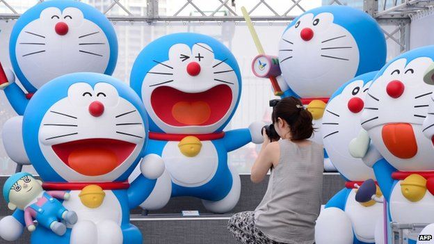 Life-size figures of Doraemon sit on the roof of the Tokyo Tower Foot Town on 18 July 2013