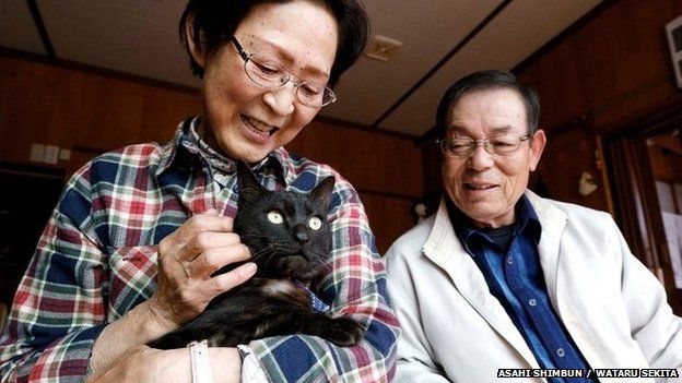 Kazuko and Takeo Yamagishi hold their cat Suika