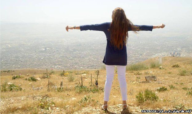 A woman standing on the top of a hill with her back to the camera and her arms outstretched - one of the images of the "My Stealthy Freedom" Facebook page