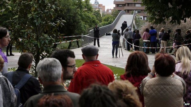 People look at police officers investigating at the site of the murder of Leon provincial council chief Isabel Carrasco in Leon, 12 May 2014